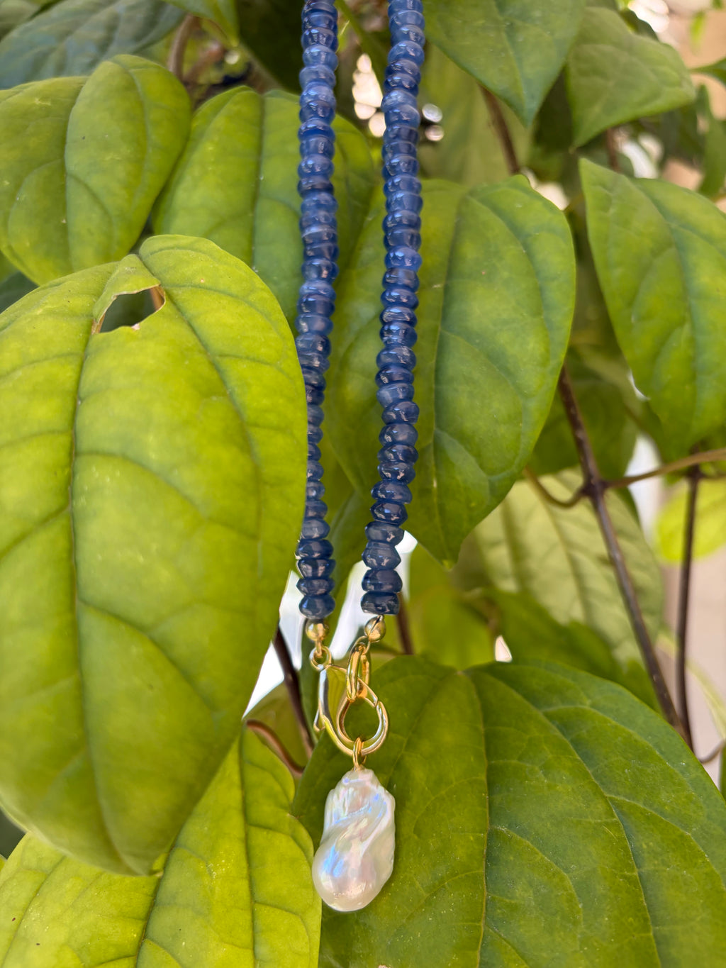 Kyanite heishi necklace with baroque pearl pendant on mannequin bust in sunlight