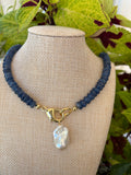 Kyanite heishi necklace with baroque pearl pendant on branch with leaves