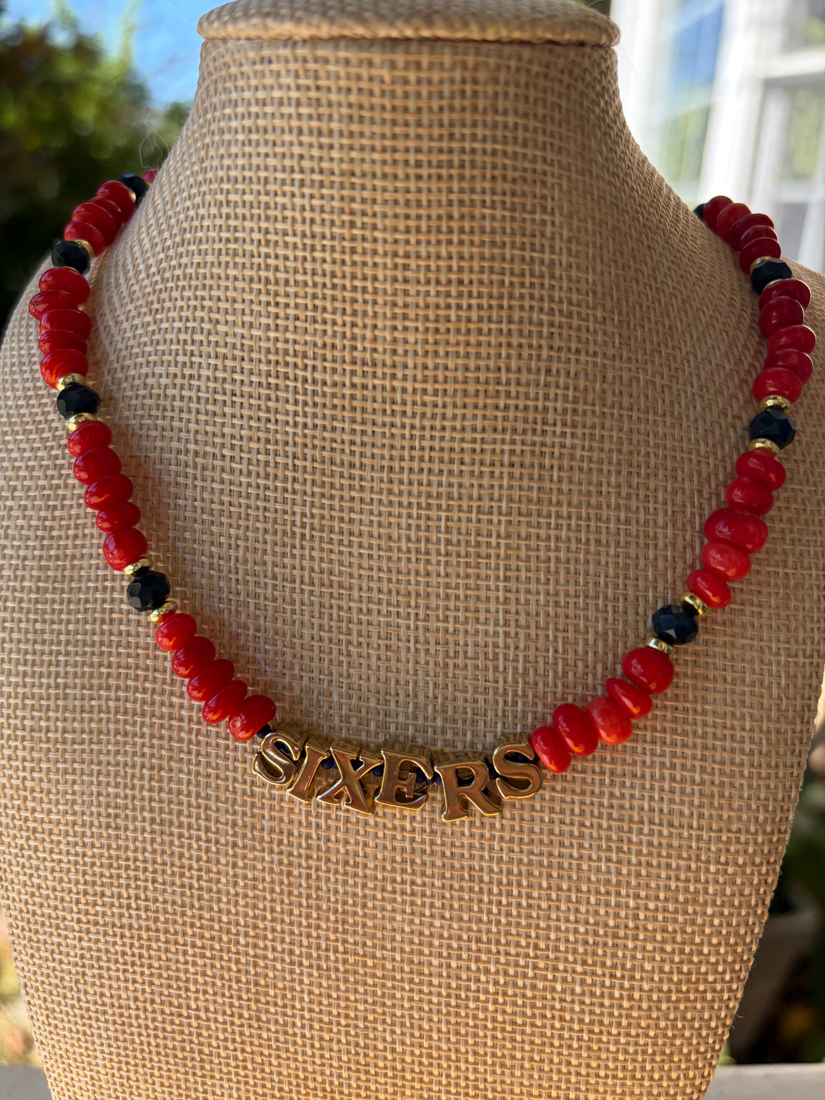 Red rondelle and navy crystal SIXERS necklace on mannequin bust side view