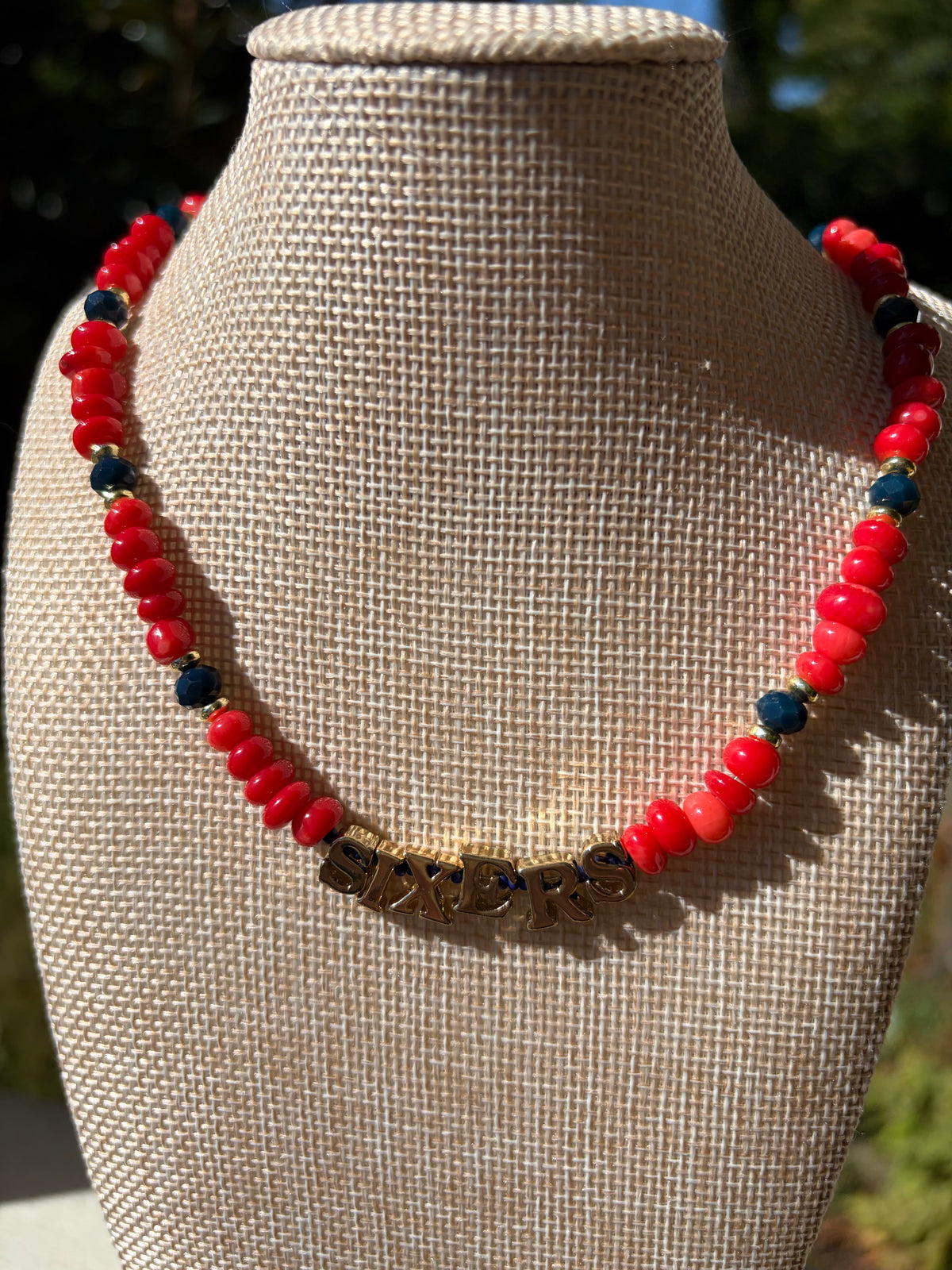 Red rondelle and navy crystal SIXERS necklace on mannequin bust front view