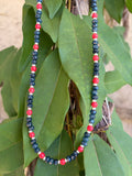 Navy crystal and red bead necklace on mannequin bust outdoor