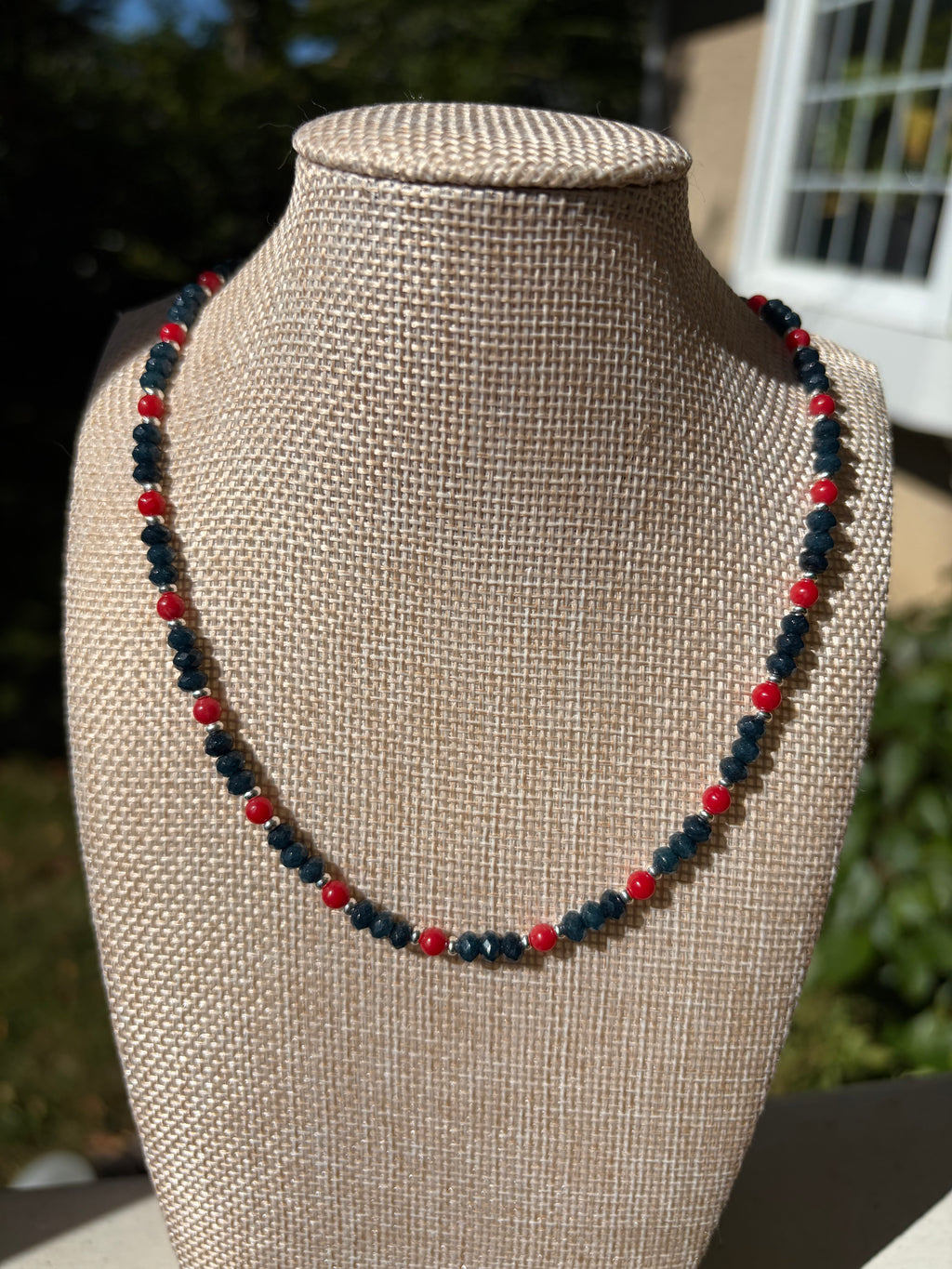 Navy crystal and red bead necklace with silver clasp on mannequin bust side view